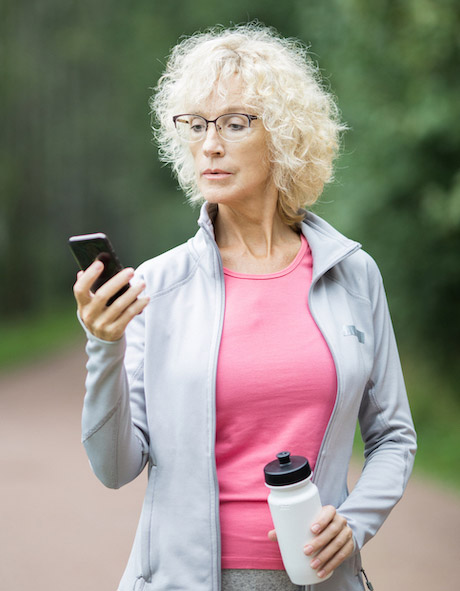 äldre aktiv kvinna som håller i telefonen